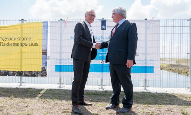 Gedeputeerde Ben de Reu en HID Theo van de Gazelle bekrachtigen de samenwerking voor duurzaamheid bij de officiële oplevering van de Flakkeese Spuisluis.